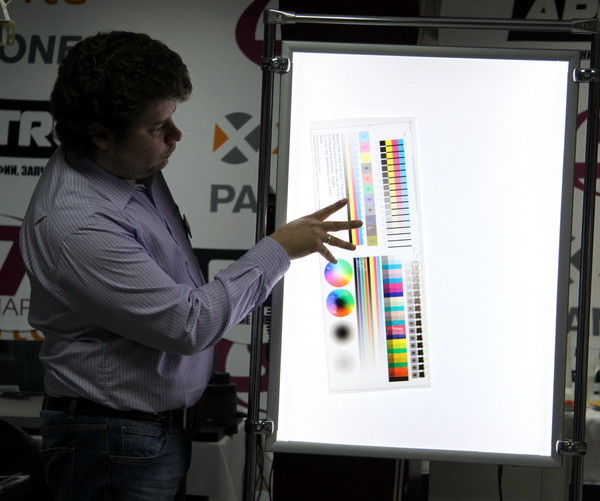 Д. Кобзарь с помощью светового короба объясняет тонкости создания профиля печати для материалов, работающих на просвет